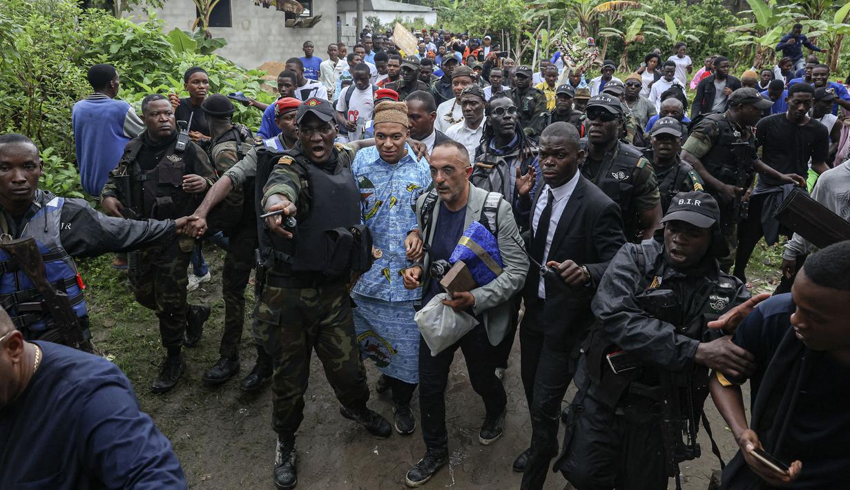 Pemain Paris Saint-Germain dan kapten Timnas Prancis, Kylian Mbappe (tengah) mengenakan pakaian tradisional saat mengunjungi desa ayahnya, Wilfrid Mbappe, di Djebale, Kamerun pada 8 Juli 2023. (AFP/Daniel Beloumou Olomo)