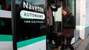 Seorang wanita menaiki bus tanpa supir (driverless) yang mulai dioperasikan di Paris, Senin (23/1). Bus tanpa sopir itu beroperasi di lajur khusus, berupa jembatan yang menghubungkan dua stasiun kereta, di timur pusat kota. (GEOFFROY VAN DER HASSELT/AFP)