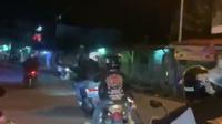 Kelompok berandalan bermotor di Garut, Jawa Barat, tengah mengendarai kendaraan secara zig-zag dan ugal-ugalan, sambil membawa samurai dan botol miras hingga mengganggu pengguna jalan lain. (Liputan6.com/Jayadi Supriadin)