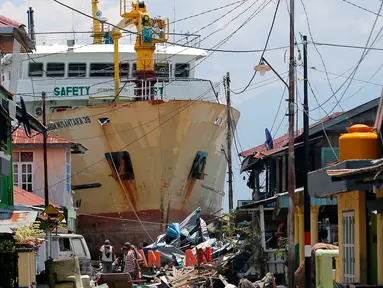 KM Sabuk Nusantara 39 terdampar di antara rumah warga setelah tsunami melanda Palu dan Donggala, Sulawesi Tengah, Selasa (2/10). Berdasarkan data di marinetraffic.com, KM Sabuk Nusantara 39 memiliki bobot mati 500 ton. (AP Photo/Tatan Syuflana)