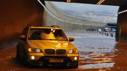Pengendara mobil berusaha melintasi terowongan yang banjir di pinggiran selatan Beirut Ouzai, Lebanon (9/12/2019). Hujan deras membuat sejumlah rumah dan kendaraan di Lebanon terendam banjir dan melumpuhkan daerah-daerah dari ibukota Beirut, Lebanon. (AP Photo/Bilal Hussein)