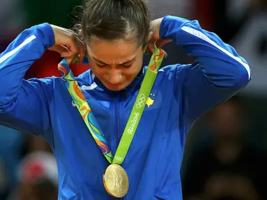 Atlet Kosovo, Majlinda Kelmendi  menyeka air mata bahagianya setelah meraih emas pada cabang judo putri Olimpiade 2016 di Rio de Janeiro, Minggu (7/8). Kelmendi menjadi atlet pertama dari Kosovo yang meraih medali Olimpiade. (REUTERS/Toru Hanai)