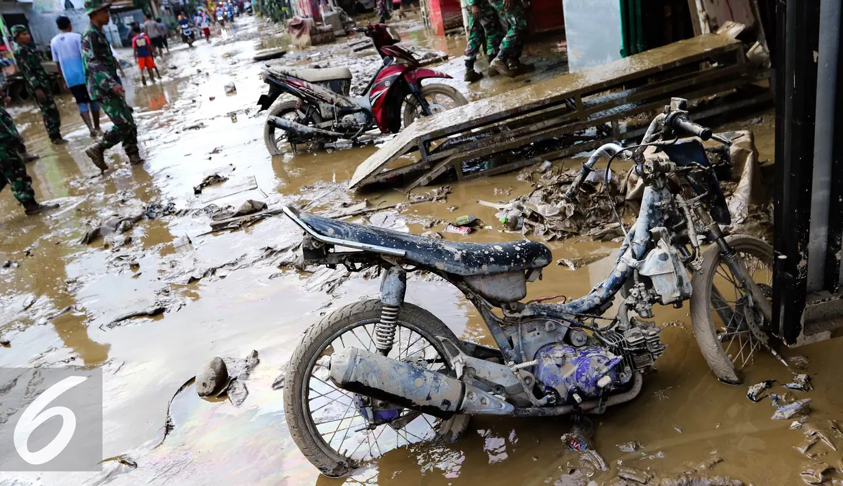 Sebuah sepeda motor dilumuri lumpur usai banjir menggenangi komplek Pondok Gede Permai Jatiasih, Bekasi, Jumat (22/04). (Liputan6.com/Fery Pradolo)