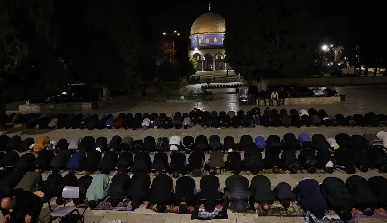 Sebagai informasi, ini merupakan Ramadan pertama sejak kesepakatan gencatan senjata antara Israel dan kelompok Hamas yang dimediasi Amerika Serikat pada 10 Oktober 2025. Tampak dalam foto, para jamaah Muslim Palestina melaksanakan salat Tarawih pada malam pertama bulan suci Ramadan di dekat Kubah Batu, kompleks Masjid Al-Aqsa, Kota Tua Yerusalem pada 17 Februari 2026. (AHMAD GHARABLI/AFP)