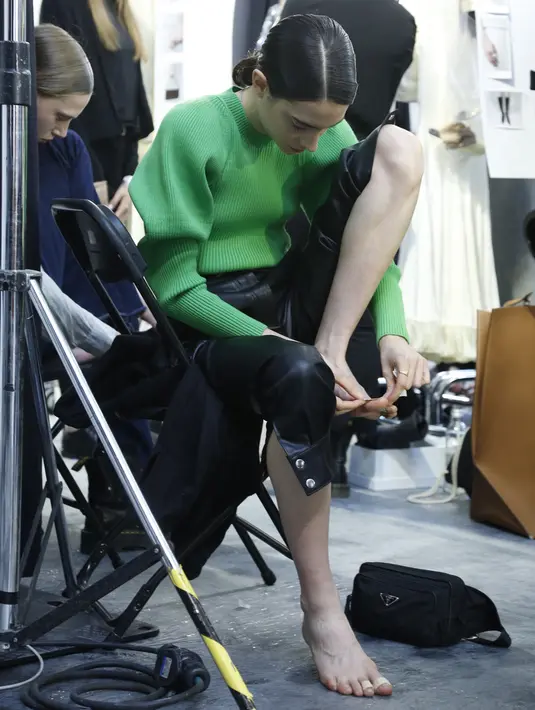 Model bersiap di belakang panggung sebelum memamerkan koleksi busana wanita Fall Winter 2020 Jil Sander selama Fashion Week di Milan, Italia, Rabu, (19/2/2020). (AP Photo/Domenico Stinellis)