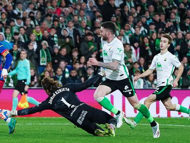 Pemain Barcelona, Ferran Torres, melewati kiper Racing Santander, Jokin Ezkieta, sebelum menjebol gawangnya pada babak 16 besar Copa del Rey di Estadio El Sardinero, Jumat (16/1/2025). (AP Photo/Miguel Oses)