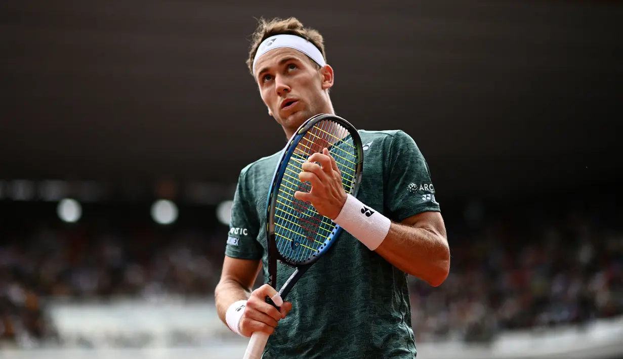 Eror yang dilakukan Casper Ruud pada poin krusial (30-40) usai melakukan back hand yang tidak akurat, memberikan keuntungan kepada Nadal. Hal tersebut sukses dimanfaatkan oleh petenis asal Spanyol itu untuk memenangi gim kesembilan dan menutup set pertama dengan skor 6-3. (AFP/Christophe Aarchambault)