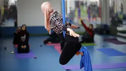Seorang wanita Palestina melakukan sesi latihan yoga di pusat pelatihan yoga wanita pertama di kota Gaza, 28 Maret 2018. Kelas yoga dengan menggunakan pusat kebugaran darurat ini bertujuan  melatih 32 perempuan sebagai pelatih Yoga. (MOHAMMED ABED/AFP)