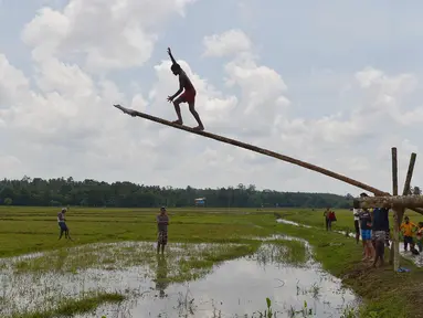 Pemuda Sri Lanka berusaha memanjat batang pohon selama perayaan Tahun Baru Sinhala dan Tamil di Bandaragama, Kolombo (21/4). Sejumlah perlombaan diadakan saat tahun baru umat Hindu, Sinhala dan Tamil yang jatuh 14 April. (AFP Photo/Lakruwan Wannirachchi)