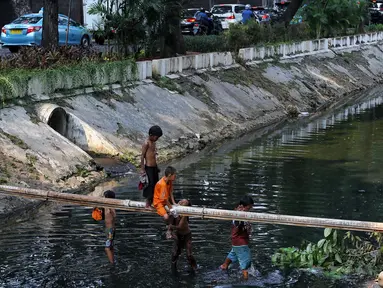 Anak-anak bermain di Kali Gresik di Jalan Muhammad Yamin, Menteng, Jakarta, Rabu (3/7/2019). Minimnya fasilitas bermain gratis, membuat anak-anak tersebut bermain ditempat yang tidak selayaknya. (Liputan6.com/Johan Tallo)