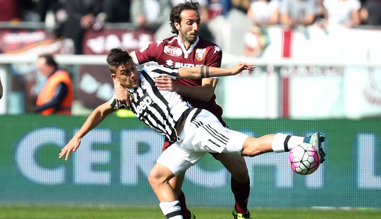 Pemain Juventus, Paulo Dybala (kiri) berebut bola dengan pemain Torino, Emiliano Moretti pada lanjutan liga Italia Serie A di  di Stadion Olimpico, Turin, Senin (21/3/2016) dini hari WIB. (AFP/Marco Bertorello)