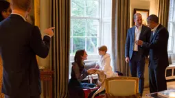 Pangeran William berbincang dengan Presiden AS Barack Obama (kanan) ketika Pangeran George tengah bermain dengan sang ibu, Kate Middleton disela jamuan makan malam di Kensington Palace, London, Jumat (22/4). (Kensington Palace/Pete Souza via Reuters)