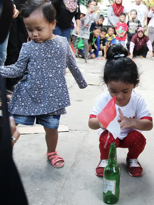 Anak Ayu Ting Ting, Bilqis Khumaira Rozak memasukkan bendera ke dalam botol saat lomba memindahkan bendera di kawasan Depok, Jawa Barat, Kamis (17/8). Lomba tersebut digelar untuk menyambut HUT ke-72 Kemerdekaan RI. (Liputan6.com/Herman Zakharia)