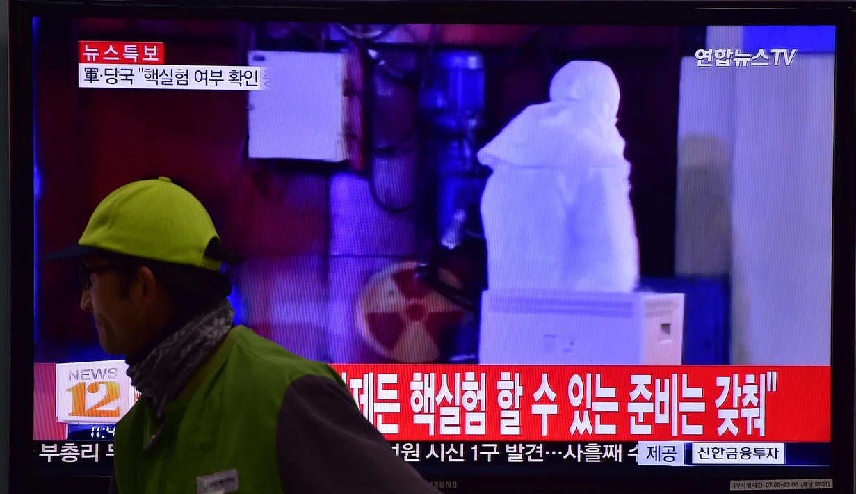 Seorang pria berjalan melewati sebuah layar TV yang menunjukkan laporan berita di sebuah stasiun kereta api di Seoul, Korea Selatan, Rabu (6/1/2016). Gempa berkekuatan 5,1 SR terdeteksi di dekat tempat uji coba nuklir Korea Utara. (AFP PHOTO/Jung Yeon-Je)