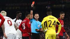 Wasit Ivan Kruzliak (tengah), memberikan kartu merah kepada pemain MU, Casemiro (tiga kiri), setelah melanggar pemain Galatasaray dalam pertandingan lanjutan Grup A Liga Champions 2023/2024 yang berlangsung di Old Trafford, Manchester, Rabu (4/10/2023) dini hari WIB. (AFP/Darren Staples)