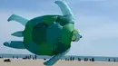 Layang-layang raksasa berbentuk kura-kura diterbangkan saat Festival Internacional del Viento (Festival Angin Internasional) di pantai Malvarrosa, di Valencia, Spanyol (23/4). (AFP/Jose Jordan)