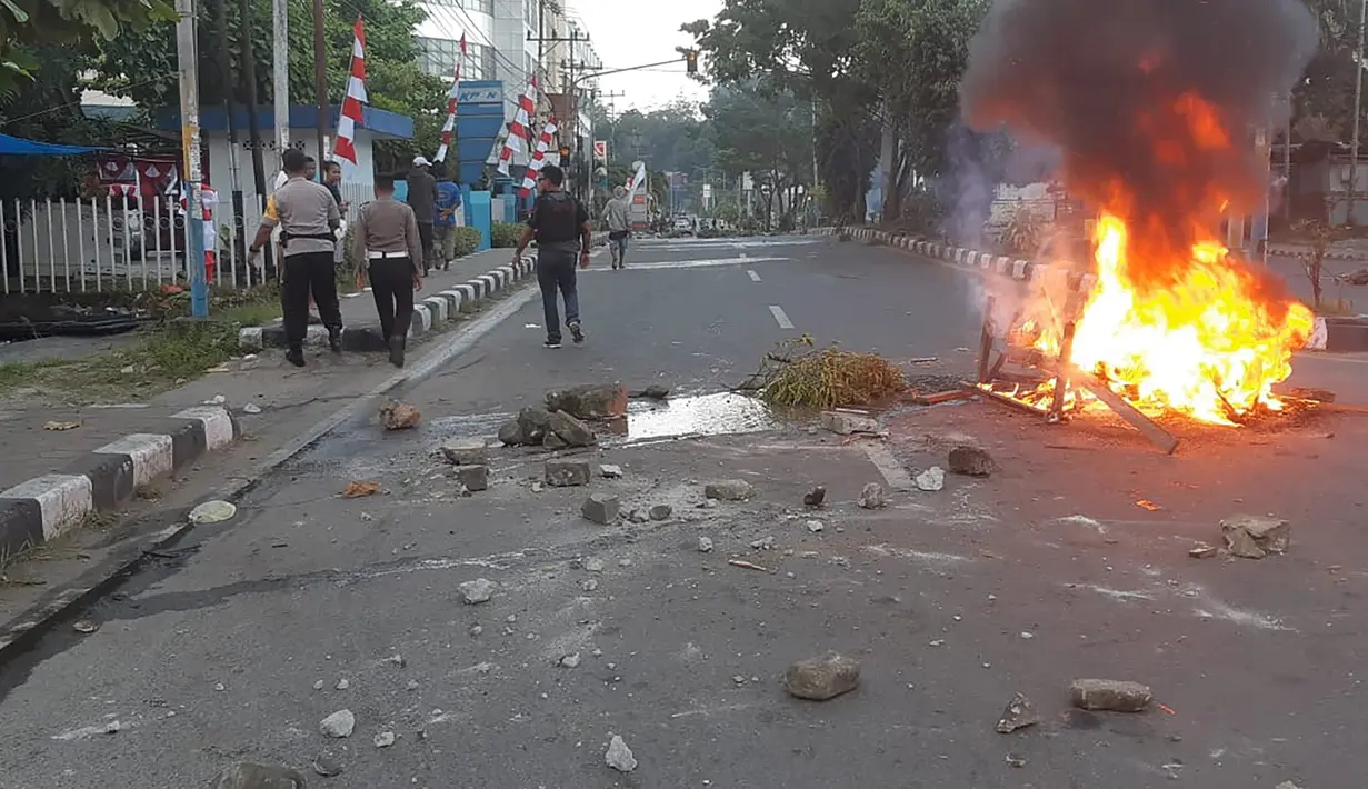 Massa turun ke jalan dalam unjuk rasa yang berujung kerusuhan di Manokwari, Papua, Senin (19/8/2019). Mereka membakar gedung DPR juga memblokade jalan dengan membakar ban sebagai buntut dari peristiwa yang dialami mahasiswa Papua di Surabaya dan Malang, serta Semarang beberapa hari lalu. (STR / AFP)