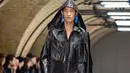 Model membawakan busana kreasi dari perancang Inggris, Craig Green selama gelaran London Fashion Week Men's di London pada 7 Januari 2019. Craig Green menampilkan busana warna-warni berbahan plastik minyak dengan pola yang rumit. (NIKLAS HALLE'N/AFP)