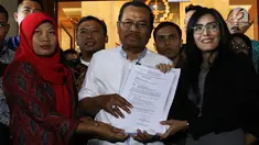 Jaksa Agung HM Prasetyo (tengah) menerima surat jaminan penangguhan eksekusi terhadap terpidana kasus pelanggaran UU ITE, Baiq Nuril Maknun(kiri)  dari anggota DPR Fraksi PDIP Rieke Diah Pitaloka di gedung Kejaksaan Agung, Jakarta, Jumat (12/7/2019). (Liputan6.com/Johan Tallo)