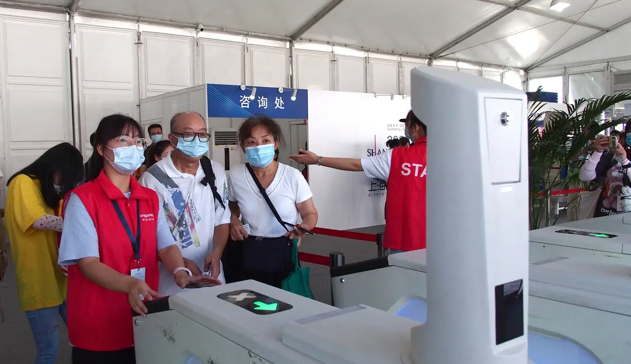 Para sukarelawan membantu pengunjung melewati pintu masuk di Pameran Buku Shanghai 2020 di Shanghai, China (12/8/2020). Pameran Buku Shanghai 2020 dimulai 12 dan 18 Agustus harus mendaftar dengan nama asli mereka, menunjukkan kode kesehatan, memakai masker, dan memeriksa suhu. (Xinhua/Ren Long)