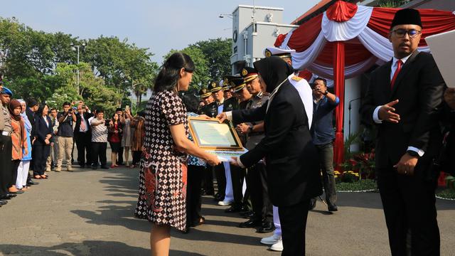 Wali Kota Surabaya Tri Rismaharini memberikan penghargaan kepada Aloysius Bayu Rendra dan korban bom di gereja Surabaya.