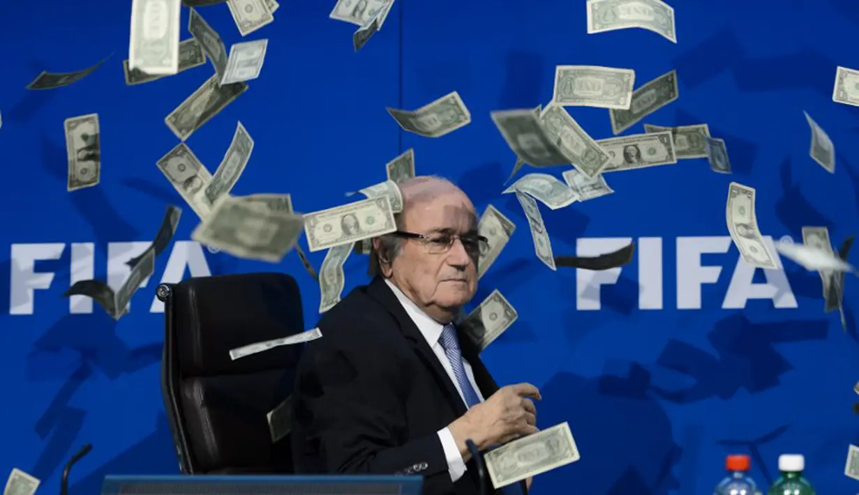 Simon Brodkin melemparkan segepok uang dollar sebagai bentuk protes atas korupsi yang terjadi di tubuh FIFA sebelum dimulainya konferensi pers di kantor FIFA di Zurich., Swiss. (20/7/2015). (AFP PHOTO/FABRICE COFFRINI)