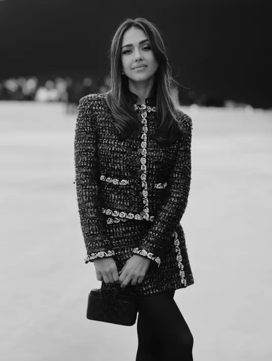 Jessica Alba tampil stunning dengan setelan rok dan jaket tweed dipadu dengan stocking hitam. Sebagai aksesori, ia jinjing tas Chanel hitam [Chanel]