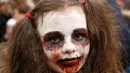 Seorang anak berpose dengan dandanan menyerupai zombie ketika berpartisipasi dalam 'Zombie Walk' di pusat Kota Kiev, Ukraina, 26 Oktober 2019. Menjelang perayaan Halloween pada 31 Oktober mendatang, warga di beberapa belahan dunia sudah mulai melakukan acara bertema horor. (AP/Efrem Lukatsky)