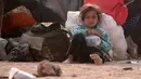 Seorang anak pengungsi Irak beristirahat usai melarikan diri dari kekerasan di Mosul yang dikuasai oleh ISIS di perbatasan Irak, Hasaka Governorate (23/10). Selain Irak pengungsi dari Suriah juga berkumpul dari dekat perbatasan Irak. (REUTERS/Rodi Said)