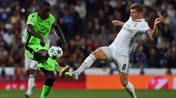 Gelandang Real Madrid, Toni Kroos, berebut bola dengan gelandang Sporting Lisbon, William Carvalho. Pada laga ini Madrid menggunakan formasi 4-3-3, sementara Sporting memakai skema 4-4-2. (AFP/Gerard Julien)