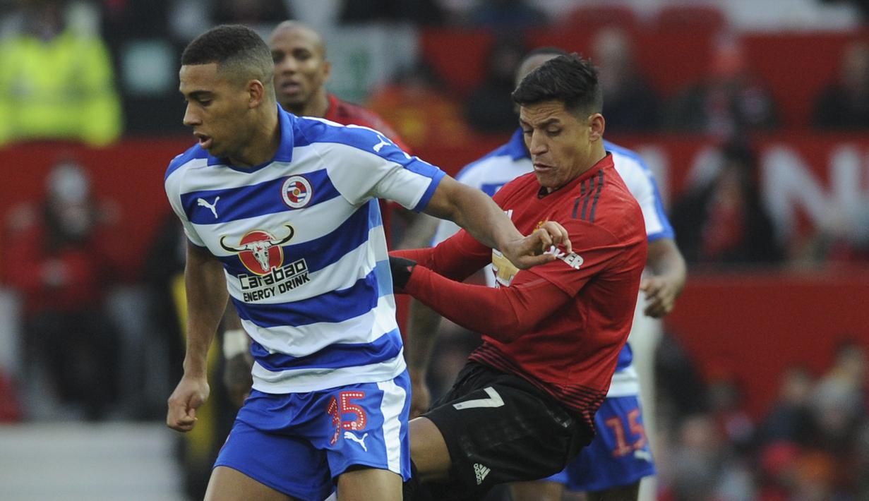 Striker Manchester United, Alexis Sanchez, berebut  bola dengan pemain Reading, Callum Harriott, pada laga Piala FA di Stadion Old Trafford, Sabtu (5/1). Manchester United menang 2-0 atas Reading. (AP/Rui Vieira)