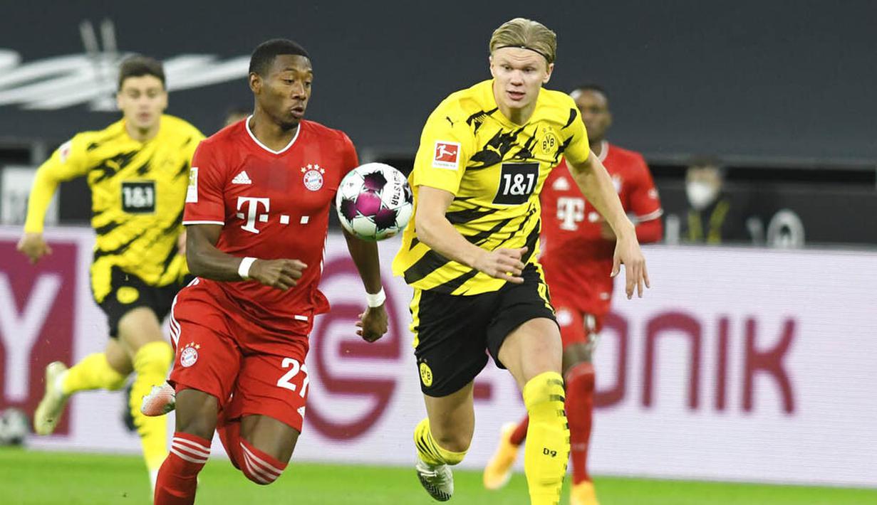 Pemain Bayern Munchen, David Alaba, berebut bola dengan striker Borussia Dortmund, Erling Haland, pada laga Bundesliga di Stadion Signal Iduna Park, Sabtu (7/11/2020). Bayern menang dengan skor 3-2. (Bernd Thissen/Pool via AP)