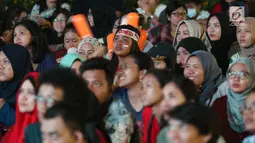 Suporter tim bulutangkis Indonesia terlihat tegang saat menyaksikan siaran langsung laga perempat final dan 16 besar bulutangkis Asian Games 2018 melalui layar lebar di kawasan kompleks GBK, Jakarta, Sabtu (25/8). (Liputan6.com/Helmi Fithriansyah)