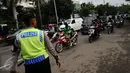 Seorang anggota polisi mengatur arus lalu lintas di Jalan Supomo, Jakarta, Senin (24/10). Indonesia Traffic Watch (ITW) menilai kemacetan di kota Jakarta saat ini sudah sampai pada tingkat 'gawat darurat'. (Liputan6.com/Helmi Fithriansyah)