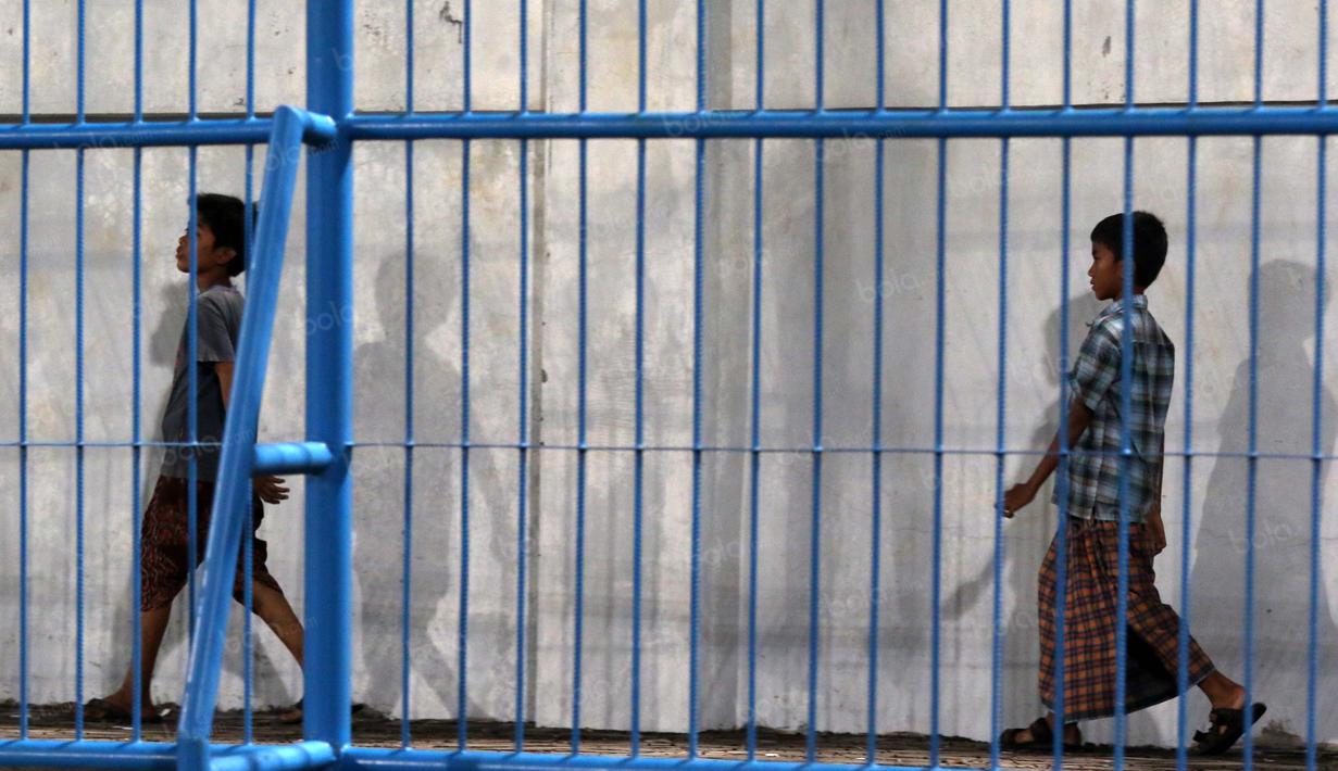 Dua bocah K-Conk Mania sedang mencari tempat duduk untuk meyaksikan  timnya  Madura United melawan Persiba Balikpapan pada Torabika SC 2016 di Stadion Gelora Bangkalan, Senin(13/6/2016).  (Bola.com/Nicklas Hanoatubun)