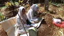 Usai melaksanakan Salat Idulfitri 1447 Hijriah/2026 Masehi, sebagian umat muslim memadati salah satu Tempat Pemakaman Umum (TPU), Cibinong, Kabupaten Bogor, Jawa Barat. Tampak dalam foto, warga saat melakukan ziarah kubur usai melaksanakan salat Idulfitri 1447 Hijriah di salah satu Tempat Pemakaman Umum (TPU), Cibinong, Kabupaten Bogor, Jawa Barat, Sabtu (21/3/2026). (Kapanlagi.com/Budy Santoso)