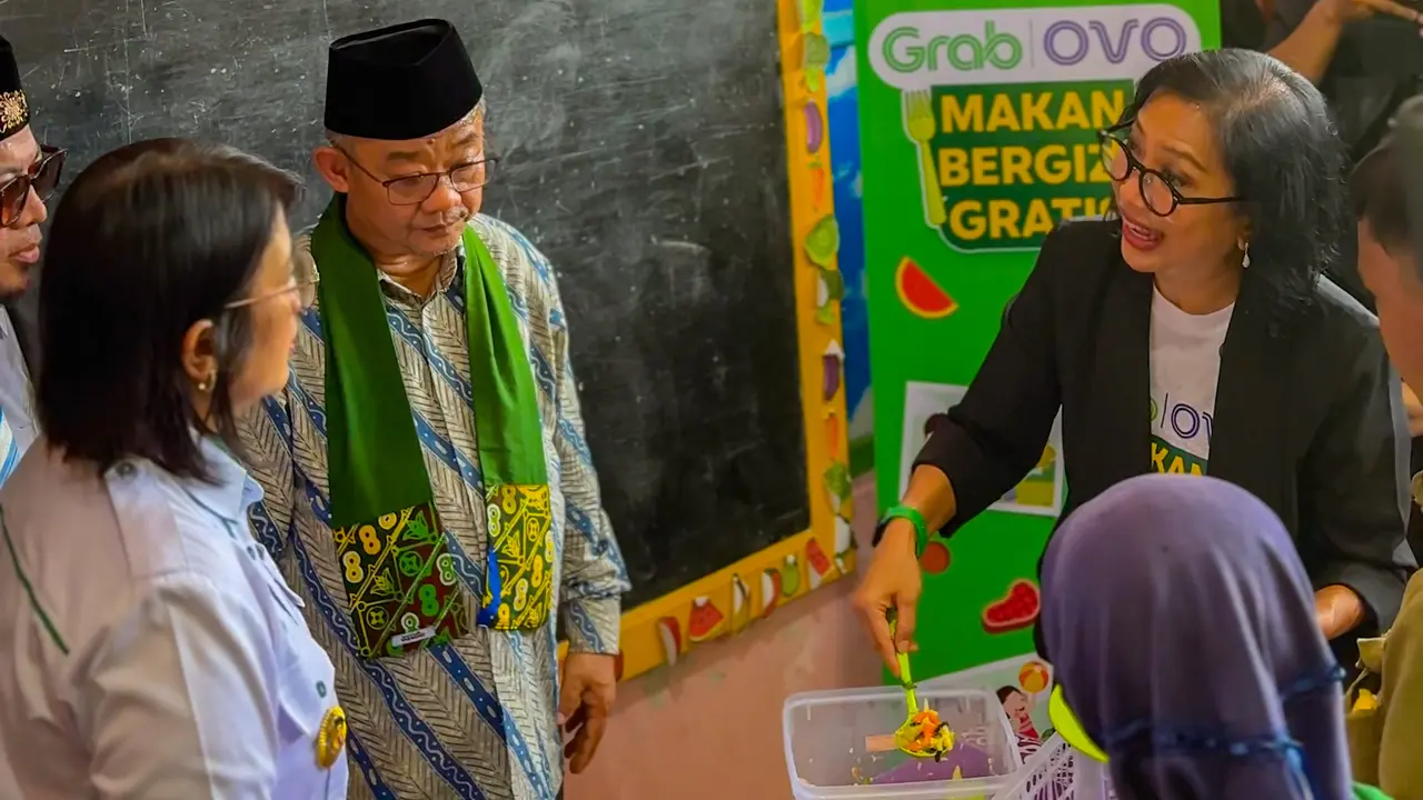 Country Managing Director Grab Indonesia Neneng Goenadi bersama Menteri Pendidikan Dasar dan Menengah Abdul Mu'ti, di program Makan Bergizi Gratis dengan metode prasmanan untuk murid SD Muhammadiyah 1 Wonopeti, Yogyakarta. (Dok Grab)