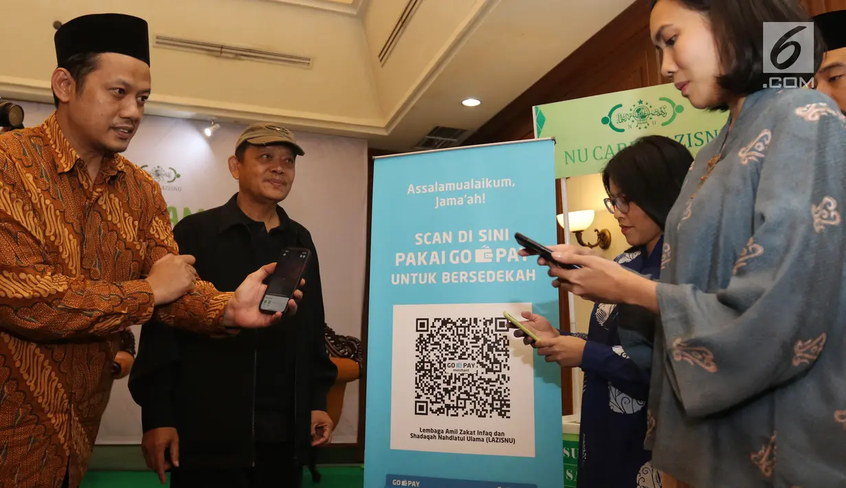 (Ki-Ka) Ketua PBNU Aizzudin Abdurrahman, Waketum PBNU M Maksum Mahfoedz, Vice President Public Affairs Gojek Siti Astrid Kusumawardhani, Head of Corcom Go-Pay Winny Triswandhani memindai QR Code untuk pembayaran zakat nontunai melalui Go-Pay di Jakarta (16/7/2019). (Liputan6.com/Angga Yuniar)