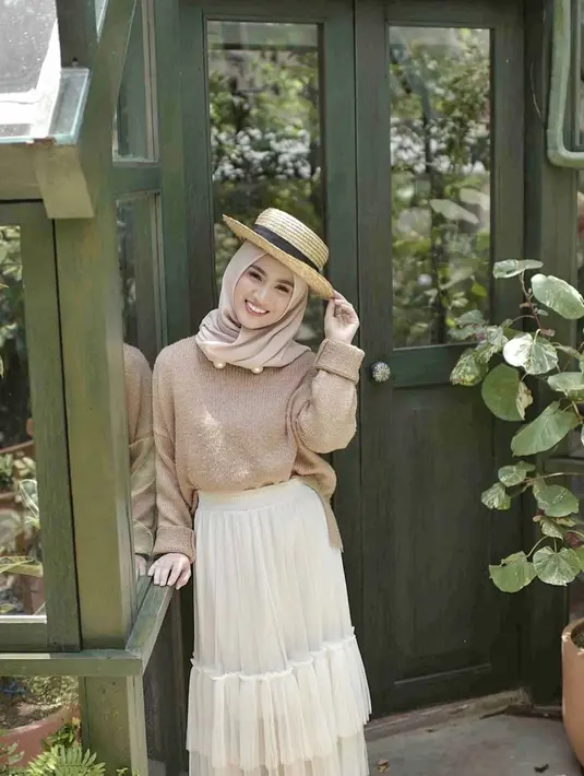 Gaya hijab dengan warna yang earth dan tambahan aksesoris topi jerami, membuat senyuman Melody semakin indah. (Liputan6.com/IG/@melodylaksani92)
