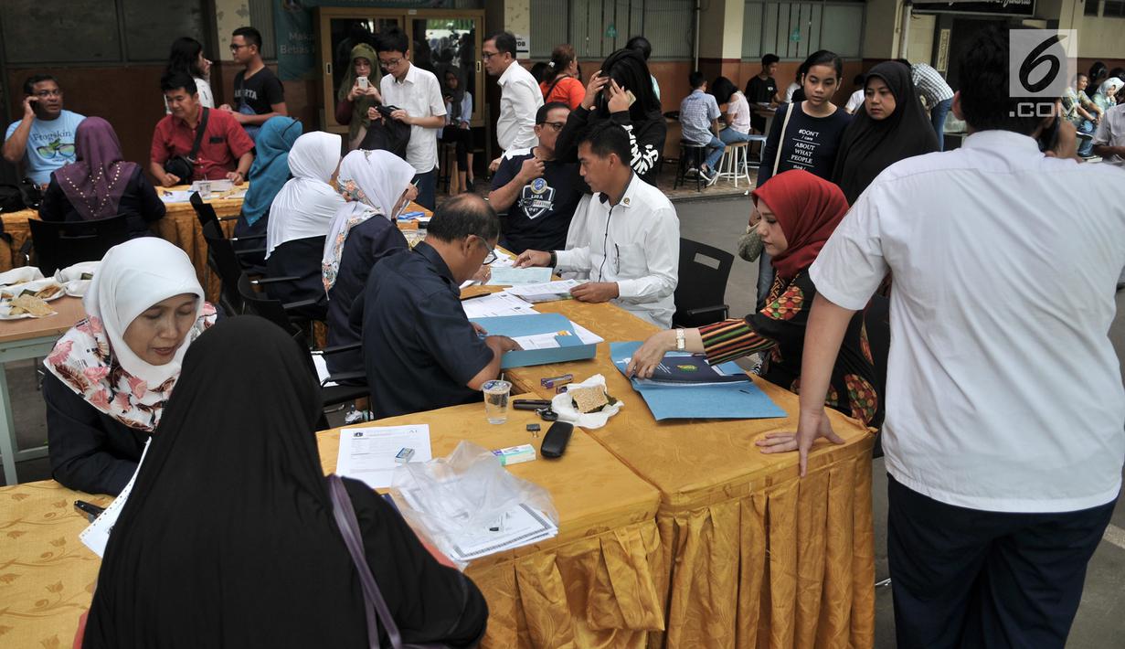 Orangtua murid melakukan pendaftaran Penerimaan Peserta Didik Baru (PPDB) Jalur Zonasi di SMA Negeri 21, Jakarta, Senin (24/6/2019). Pada hari pertama, lebih dari 750 calon peserta didik baru telah mendaftar di SMA Negeri 21. (merdeka.com/Iqbal Nugroho)