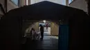 Petugas medis Palestina memeriksa suhu seseorang di dalam tenda sementara di pintu masuk Rumah Sakit al-Quds, di Kota Gaza, 7 September 2020. Lusinan petugas kesehatan garis depan telah terinfeksi COVID-19, memberikan pukulan baru ke rumah sakit yang kelebihan beban. (AP Photo/Khalil Hamra)