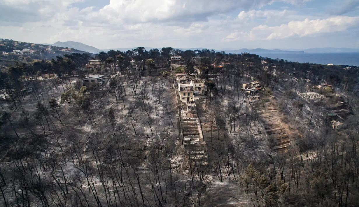 Pemandangan udara menunjukkan kerusakan yang disebabkan oleh kebakaran hebat di dekat Desa Mati, dekat Athena, Selasa (24/7). Selain menewaskan 74 orang, 170 lainnya terluka dalam kebakaran hutan tersebut. (Savas Karmaniolas/AFP)