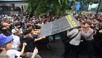 Pengunjuk rasa terlibat aksi saling dorong ketika mencoba membuka blokade aparat keamanan saat berunjuk rasa di kawasan jalan Jenderal Sudirman, Jakarta, Jumat (12/6/2026). (merdeka.com/Arie Basuki)