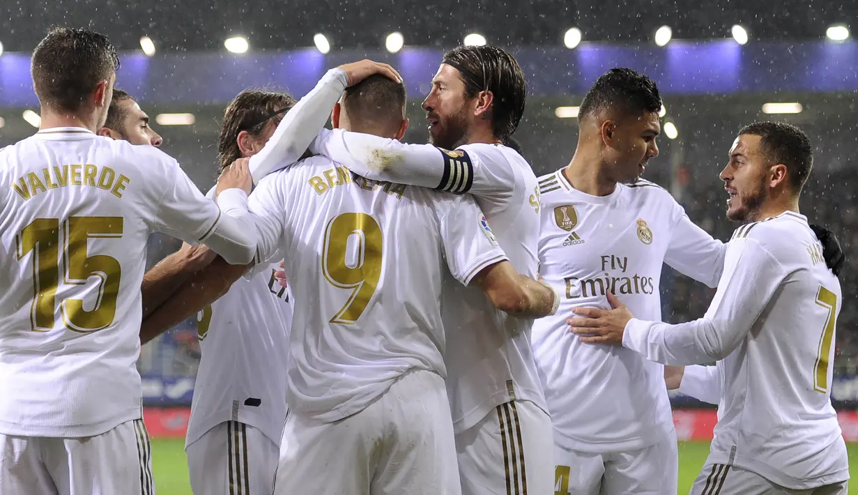 Para pemain Real Madrid merayakan gol yang dicetak Karim Benzema ke gawang Eibar pada laga La Liga Spanyol di Stadion Ipurua, Eibar, Sabtu (9/11). Eibar kalah 0-4 dari Madrid. (AFP/Ander Gillenea)