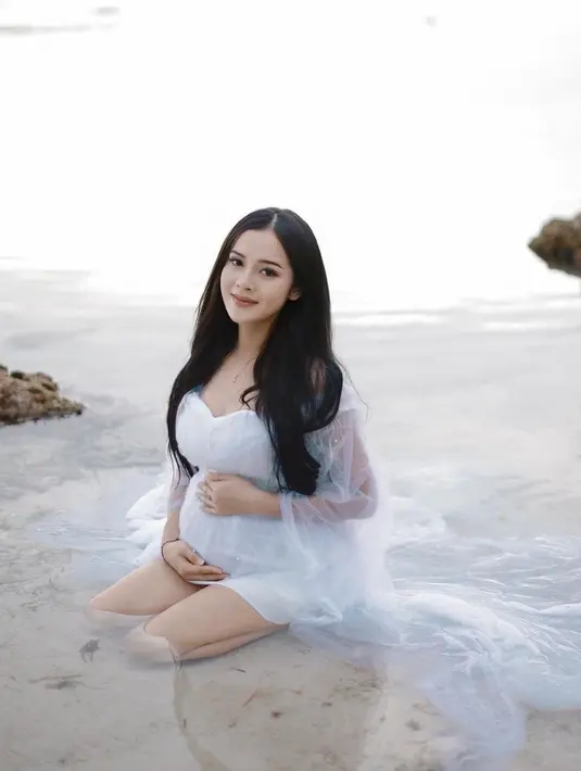 Berpose di pantai, Bella tampil cantik mengenakan sebuah dress putih. Bak mermaid, Bella Bonita tampil menawan dengan mini dress yang memiliki detail tulle panjang sebagai outer. Rambut hitam panjangnya dibiarkan tergerai dan Bella tampil dengan makeup minimalis yang glowing. [Foto: Instagram/bellabonita_r.a]