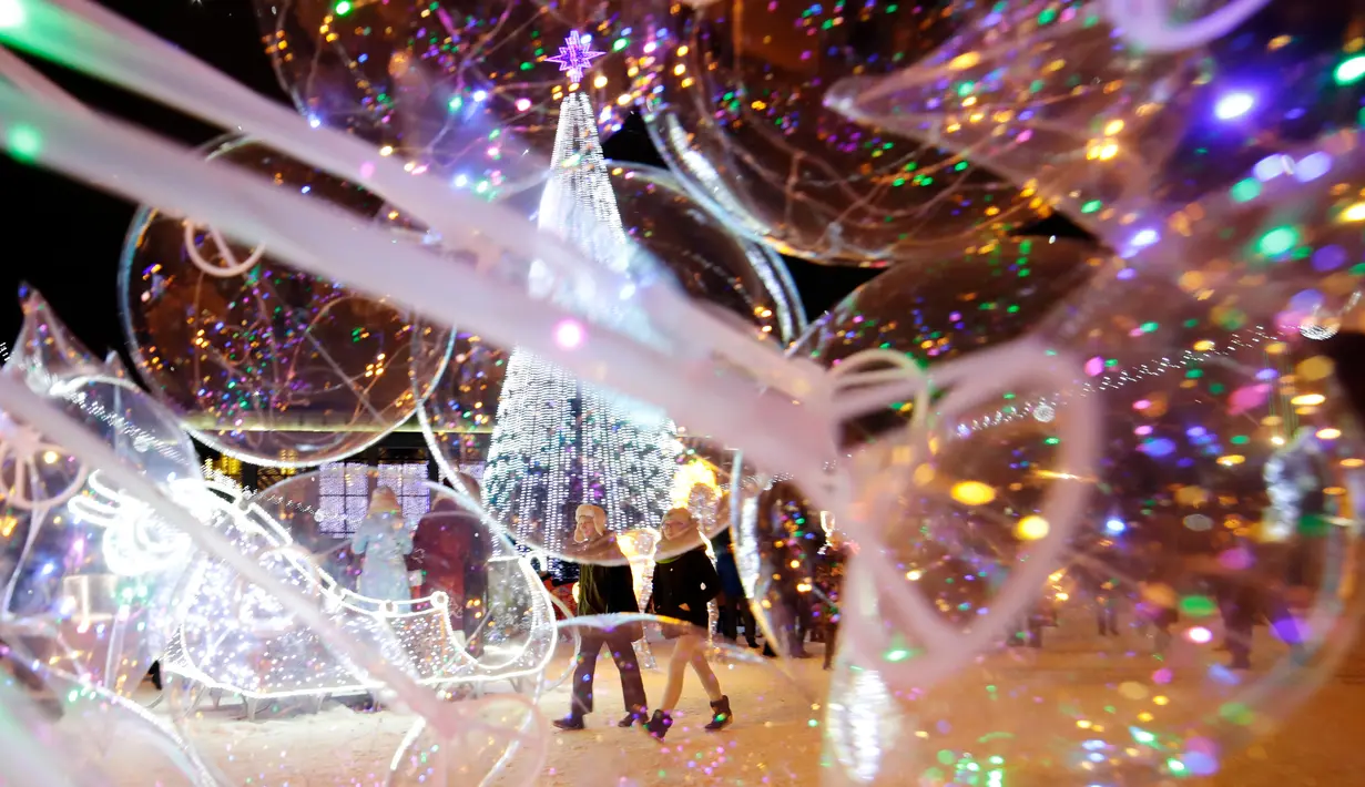 Sebuah pohon tahun baru dipajang di Octyabrskaya Square dan dekorasi untuk menyambut perayaan Natal 2018 dan Tahun Baru 2019 di Minsk, Belarus, Selasa (18/12). (AP Photo/Sergei Grits)