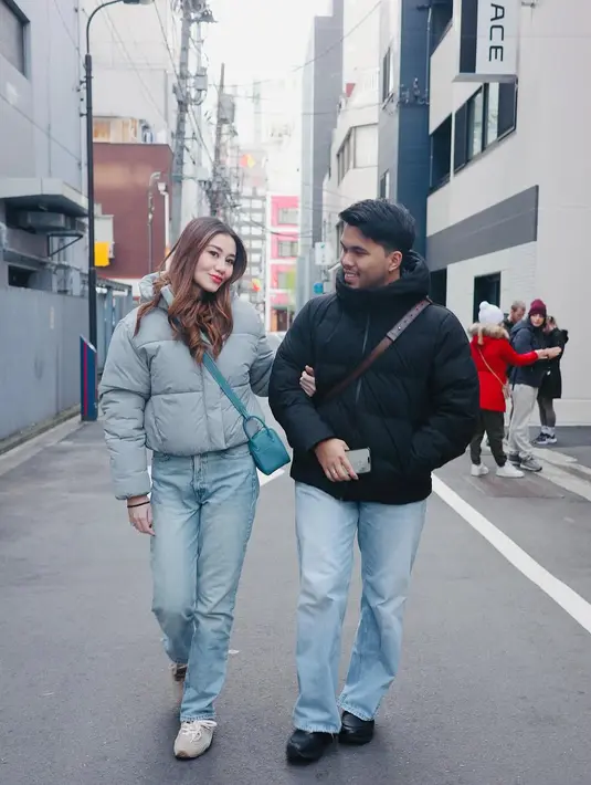 Aaliyah Massaid dan Thariq Halilintar tampil kompak dengan puffer jacket meski beda warna. Bahkan keduanya kenakan celana light jeans dan sling bag [@aaliyah.massaid]