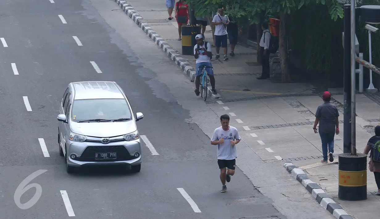 Warga melakukan aktivitas olah raga pagi di kawasan Thamrin, Jakarta, (10/7). Meskipun tidak diberlakukannya car free day di minggu pertama Idul Fitri namun masih ada masyarakat yang memanfaatkan sepinya jalanan Ibu Kota. (Liputan6.com/Angga Yuniar)