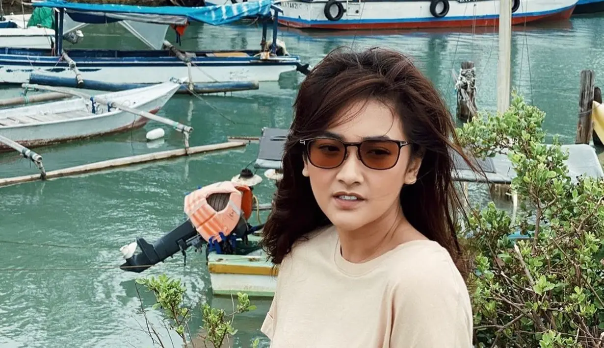 Pemilik nama lengkap Nadya Arina Pramudita memang memiliki hobi traveling. Gayanya saat traveling pun sangat simpel namun tetap keren. Seperti saat ia tampil dengan mengenakan kaus dan kacamata cokelat saat berada di pinggir laut. (Liputan6.com/IG/@nadyaarina)