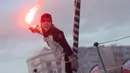 Kapten kapal layar tunggal asal Prancis, Clarisse Cremer merayakan kemenangan dengan membakar suar usai melintasi garis finish di lepas pantai Les Sables-d'Olonne, Prancis. (Foto: AFP/Loic Venance)
